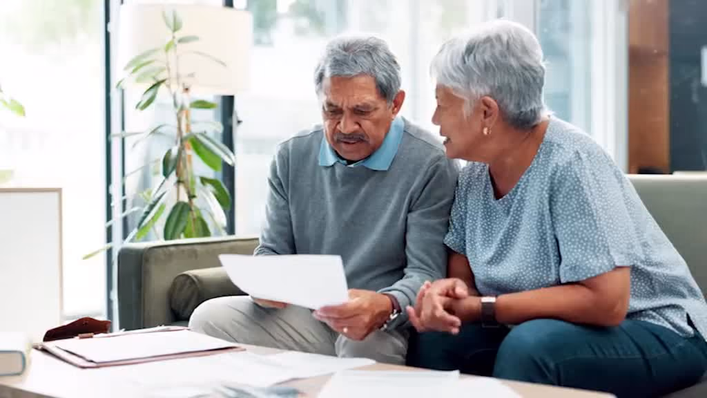 A stressed couple reviewing paperwork together.